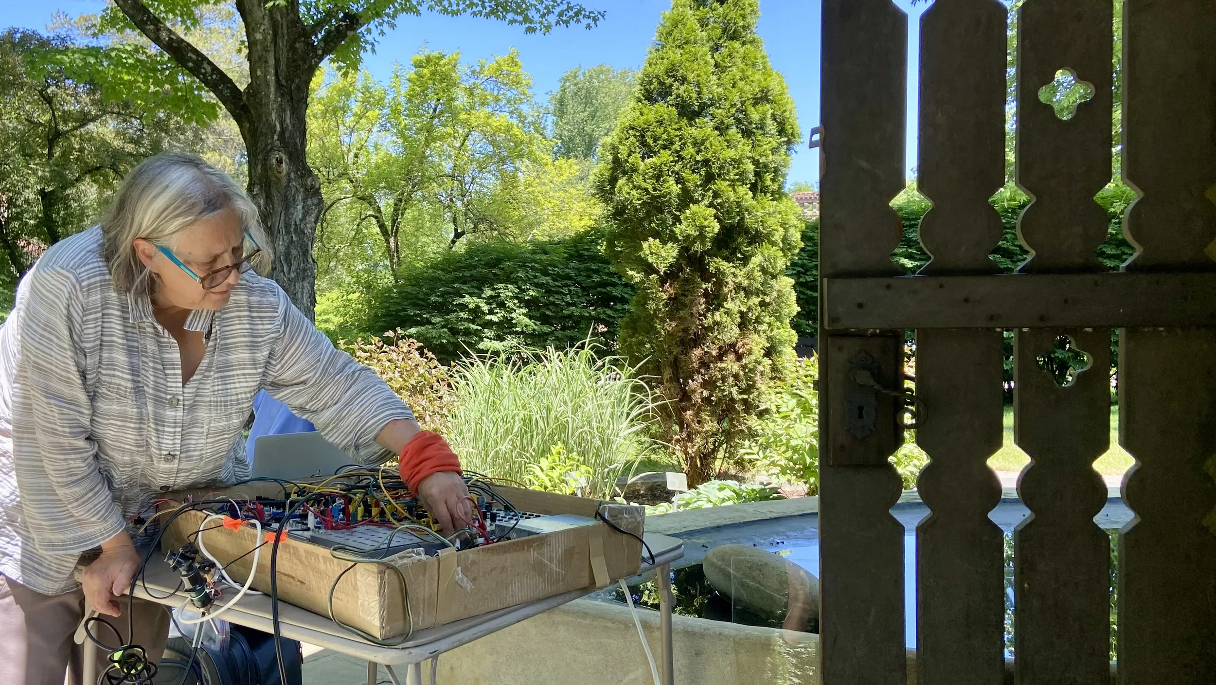 Liz Phillips adjusts a synthesizer outdoors in Spring.